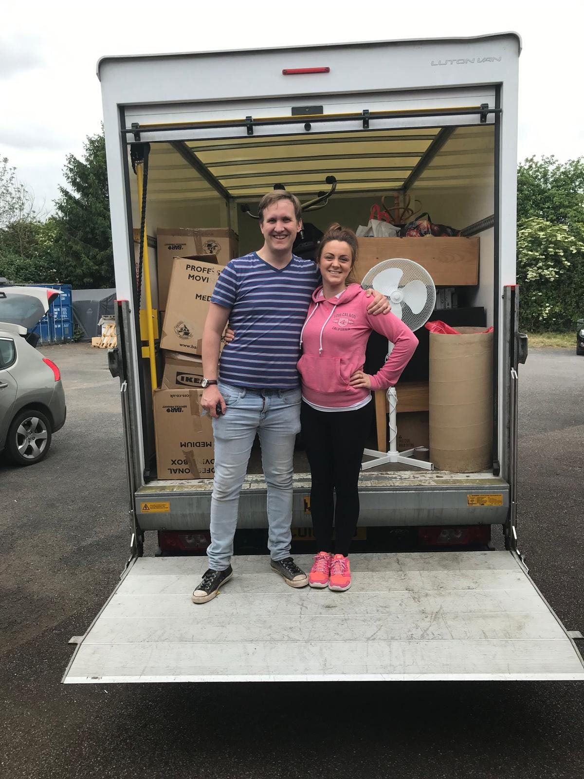 A couple celebrating on the back of a moving truck